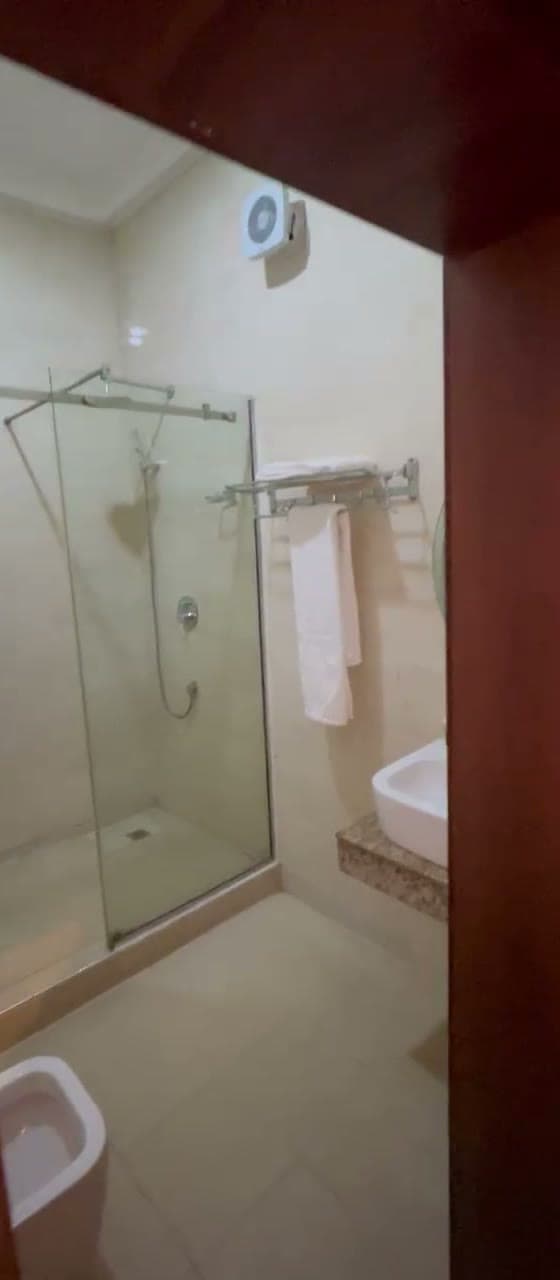 En-suite bathroom with a walk-in glass shower, towel rail and basin