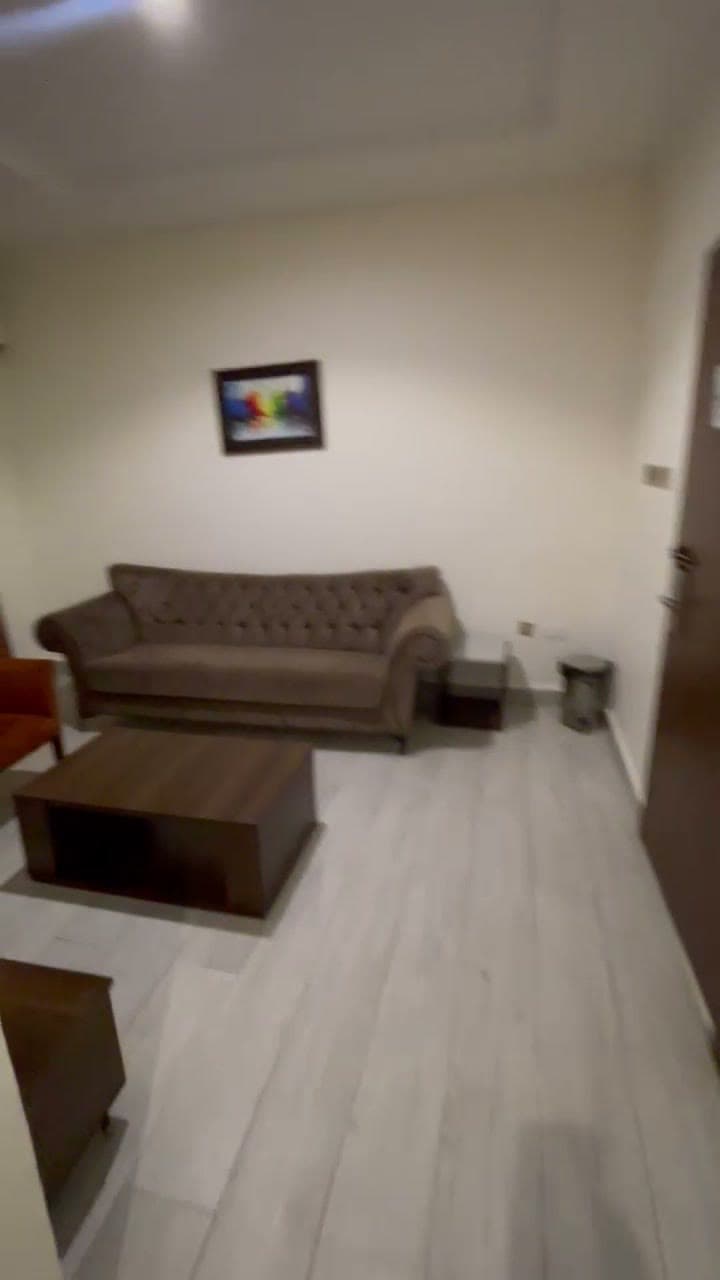 Suite lounge with a tufted brown sofa, an orange armchair and a wooden coffee table